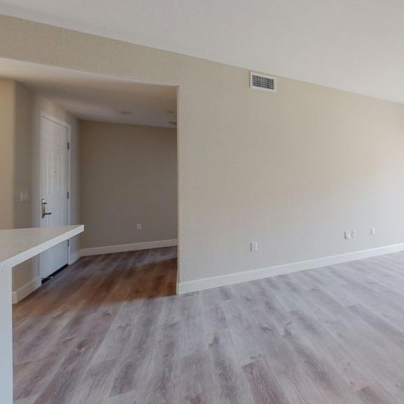 an empty living room with wood flooring and a large window at heritage landing apartments, chico, california