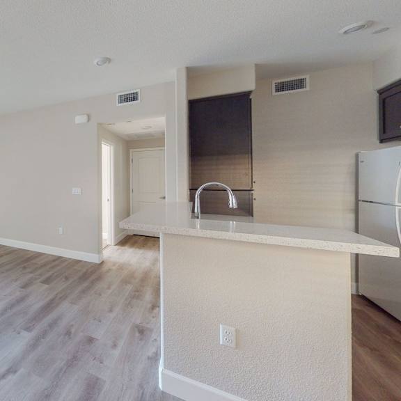 an empty kitchen and living room with hardwood flooring at heritage landing apartments, chico, california