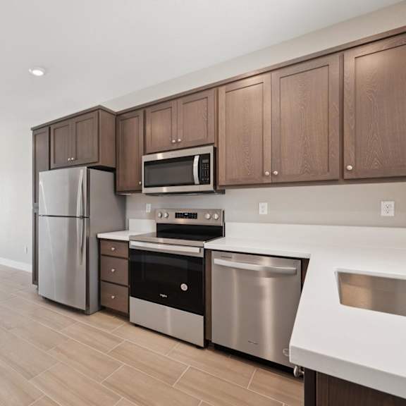 a kitchen with stainless steel appliances at montessa apartments, california