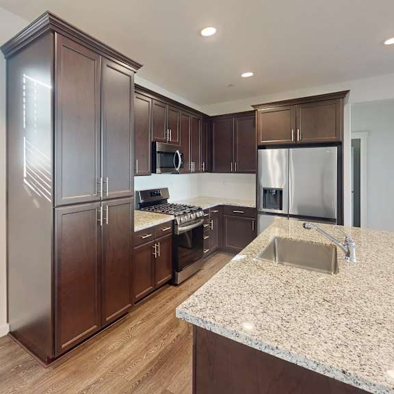 a kitchen with a granite countertop and wooden cabinets.