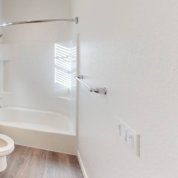 a white bathroom with a toilet, sink, and bathtub.