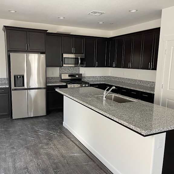 a kitchen with black cabinets and a granite countertop.