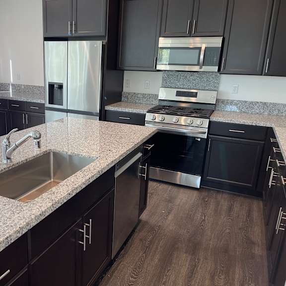 a kitchen with black cabinets and a granite countertop.