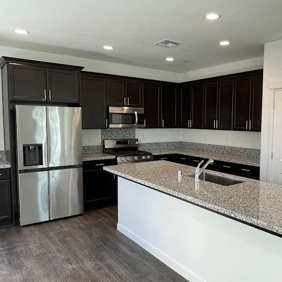 a modern kitchen with a granite countertop and stainless steel appliances.