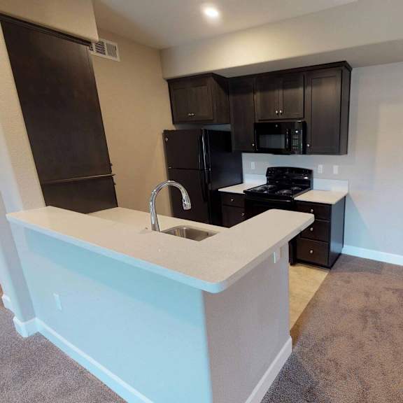 a kitchen with black cabinets and a counter with a sink at edgewater, pittsburg california 