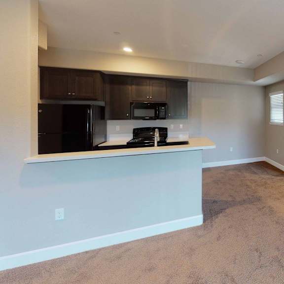 an empty living room with a kitchen and a counter top at edgewater, pittsburg, 94565  