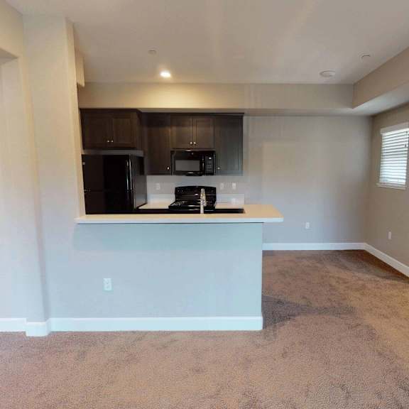 an empty living room and kitchen with a microwave and a counter at edgewater, pittsburg  