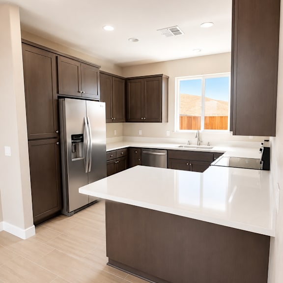 a kitchen with a refrigerator, cabinets, and a counter.