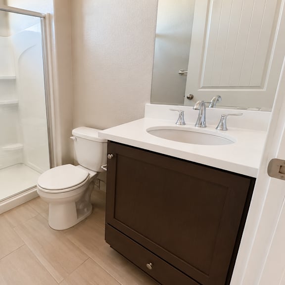 a white toilet sits next to a sink in a bathroom.