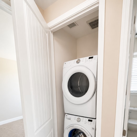 a white washing machine is in a small space.