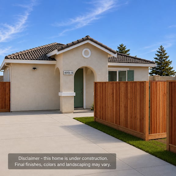 a house under construction with a wooden fence and a green door.