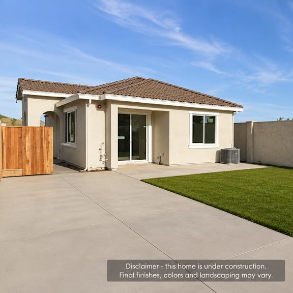 a house under construction with a wooden fence and a green lawn.