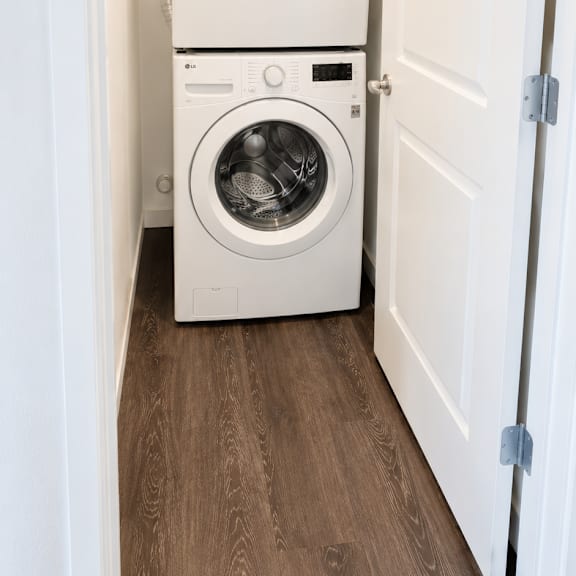 a white washing machine and dryer in a small laundry room.