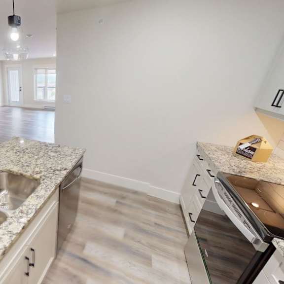 a kitchen with a granite countertop and stainless steel appliances.