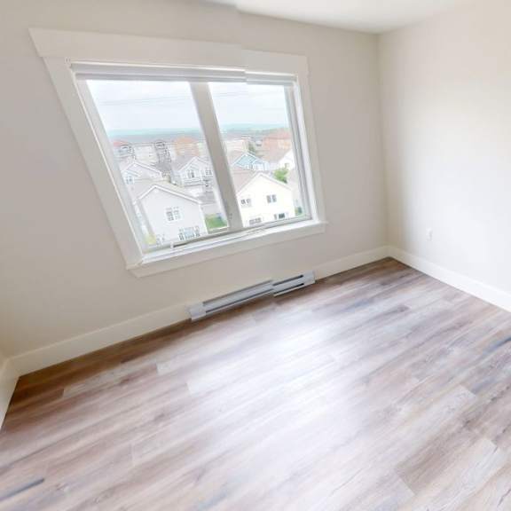 a room with a window overlooking a residential area.