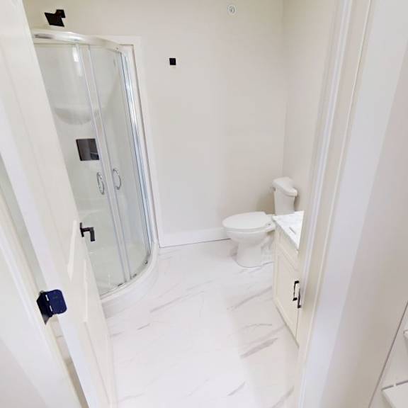 a white bathroom with a toilet and sink.