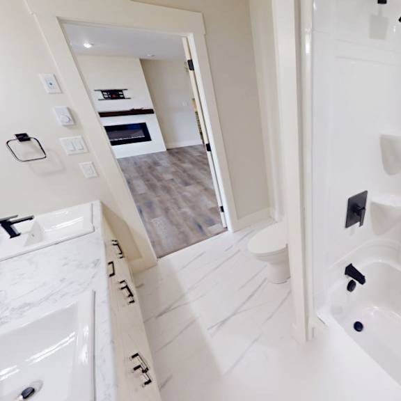 a white bathroom with a walk in shower and a sink.