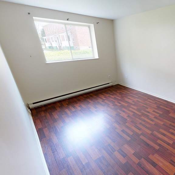 a room with wooden flooring and a window.