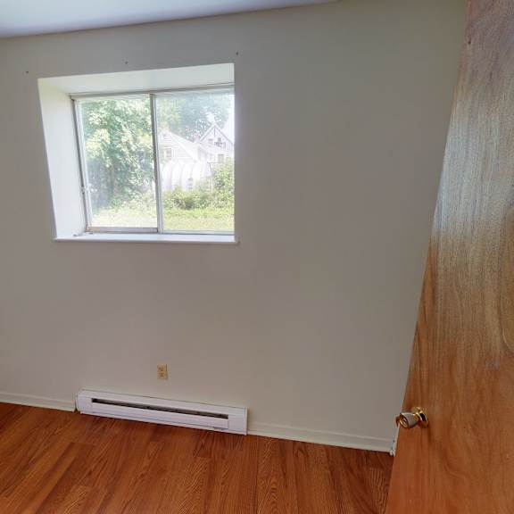 a room with a window and a wooden floor.