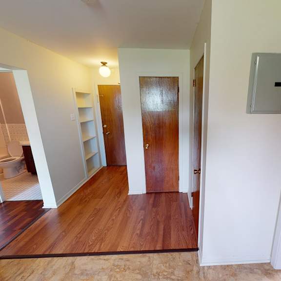 a hallway with a wooden floor and white walls.