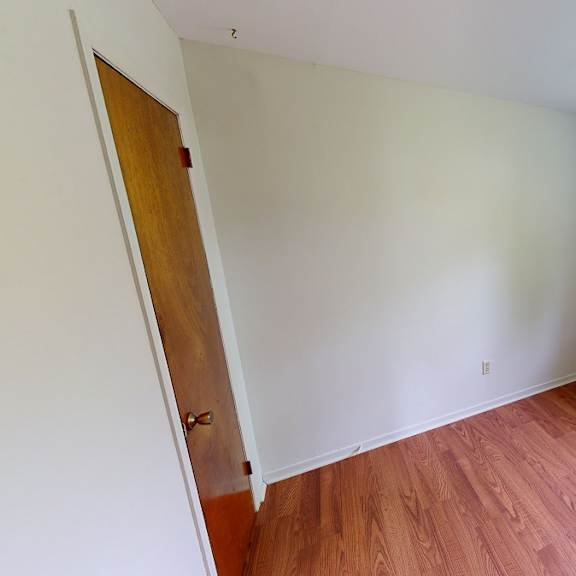a room with a wooden floor and a window.