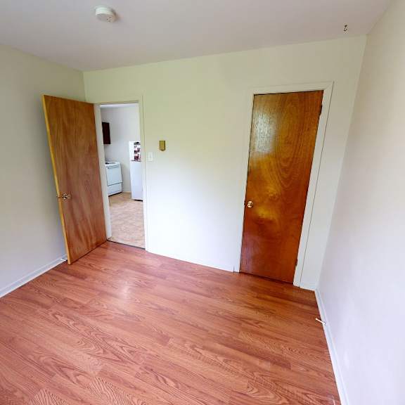 a room with wooden floors and two doors.