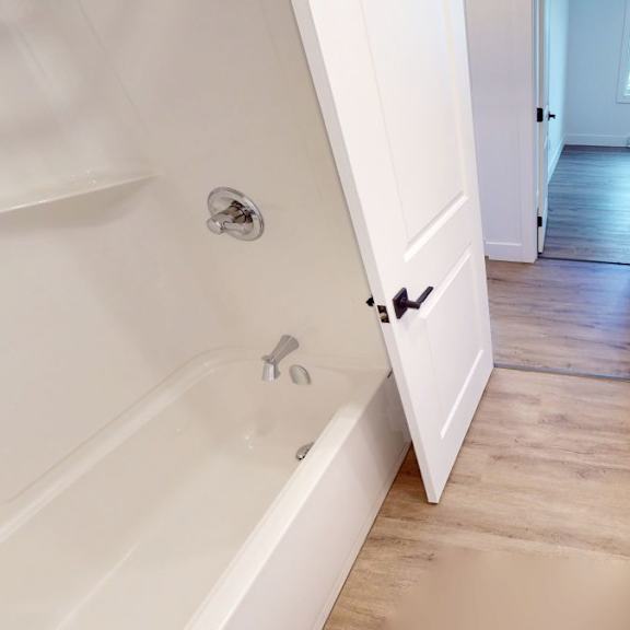 a white bathroom with a sink and a bathtub.