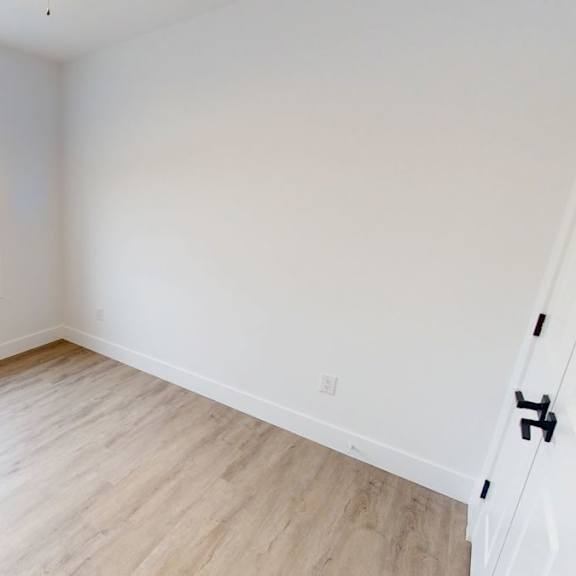 a room with a window and wooden flooring.
