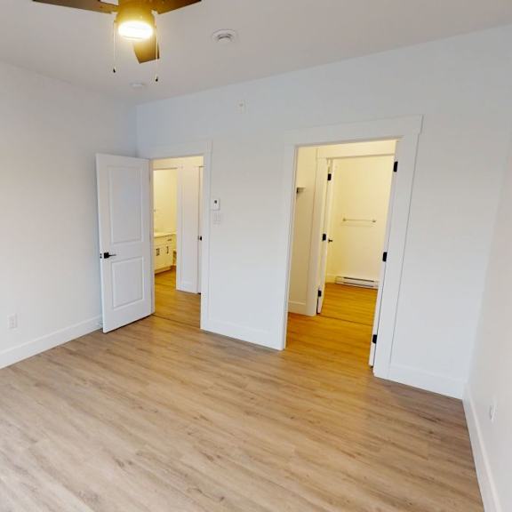 a room with a ceiling fan and two doors.