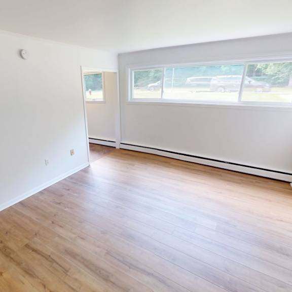 a room with wooden flooring and a window.