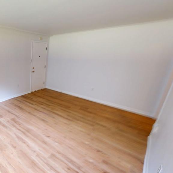 a room with wooden flooring and white walls.