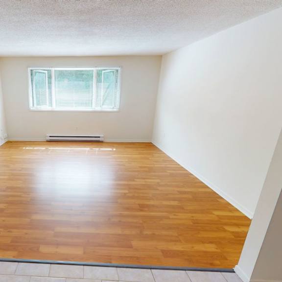 a room with wooden flooring and a window letting in light.