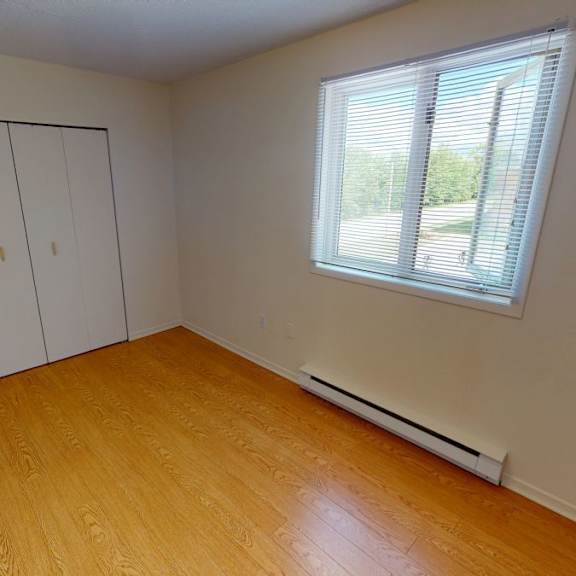 a room with a window and a wooden floor.