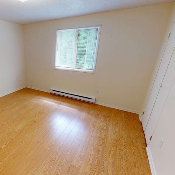 a room with wooden flooring and a window.