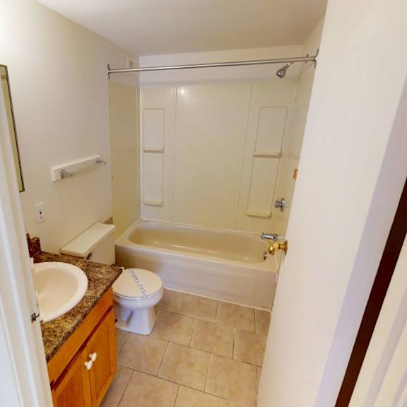 a bathroom with a toilet, sink, and bathtub.