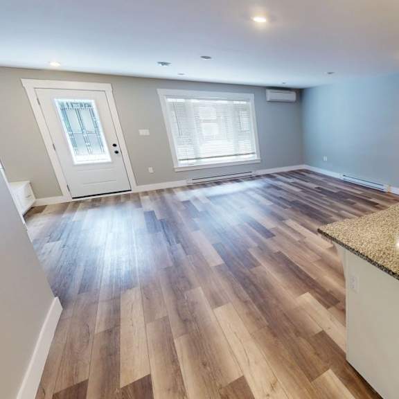a kitchen with a granite countertop and wooden flooring.