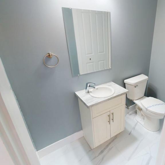a bathroom with a sink, toilet, and mirror.