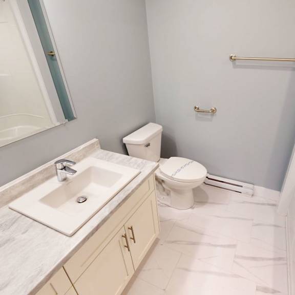 a bathroom with a toilet, sink, and bathtub.