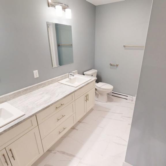 a bathroom with a sink, mirror, and toilet.