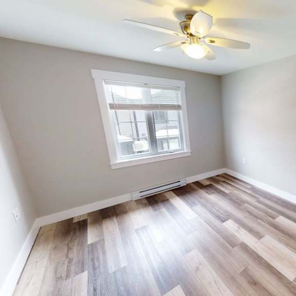 a room with a ceiling fan and a window.