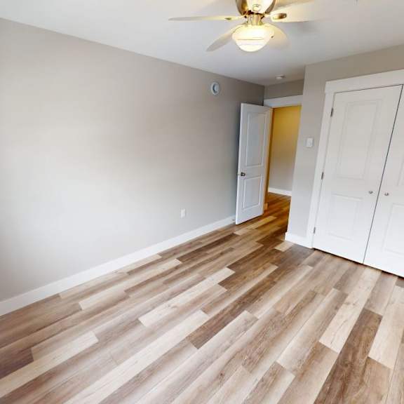 a room with wooden flooring and a ceiling fan.