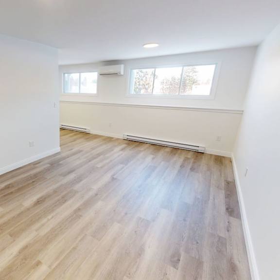 a room with wooden flooring and white walls.