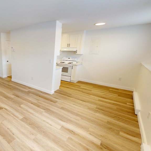 a room with wooden flooring and white walls.