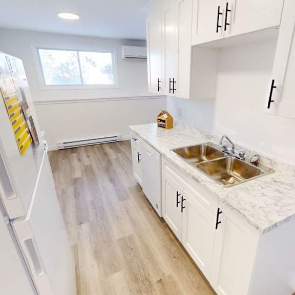 a kitchen with white cabinets and a marble countertop.