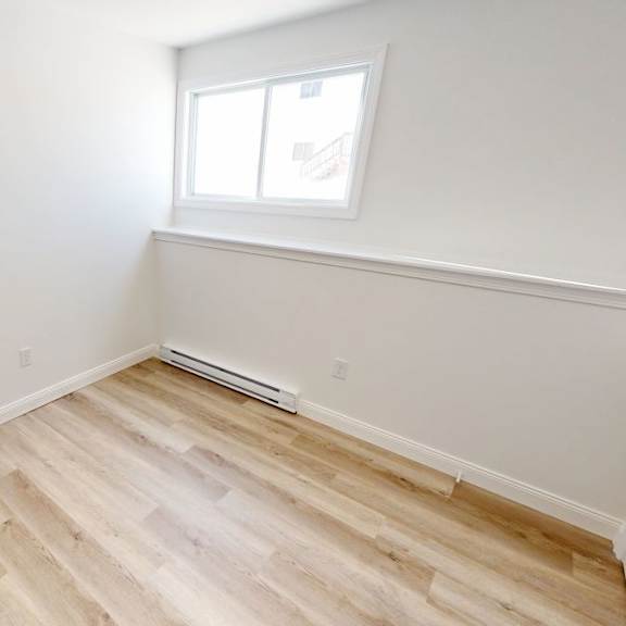 a room with a window and a wooden floor.