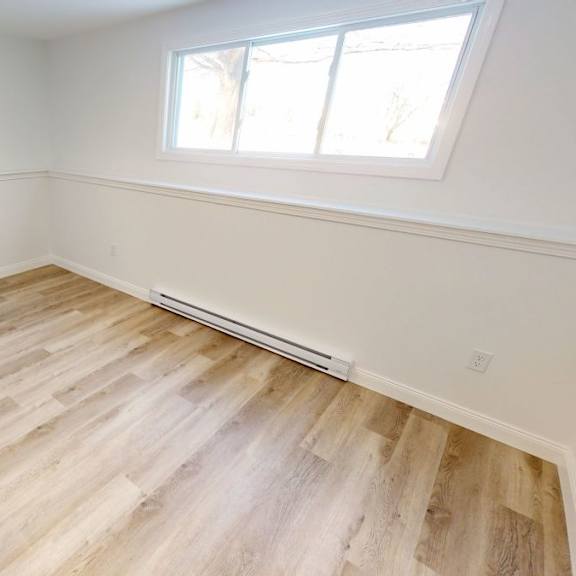 a room with wooden flooring and a window.