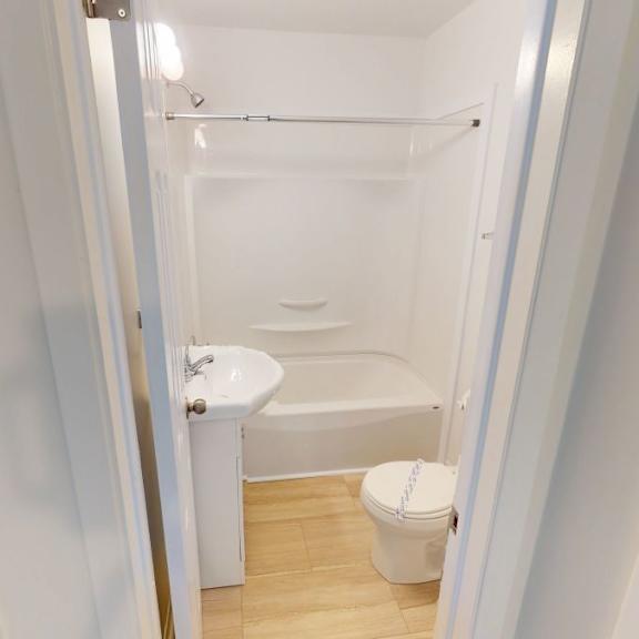 a white bathroom with a toilet, sink and bathtub.