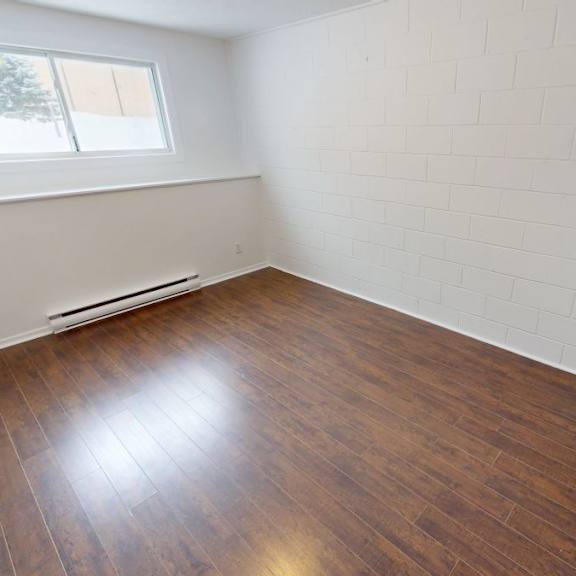 a room with a window and a wooden floor.