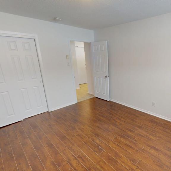 a room with a wooden floor and white walls.
