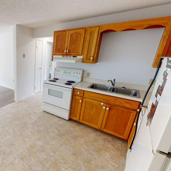 a kitchen with wooden cabinets and white appliances.